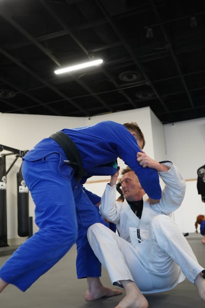 Sparring on the mats in a blue gi